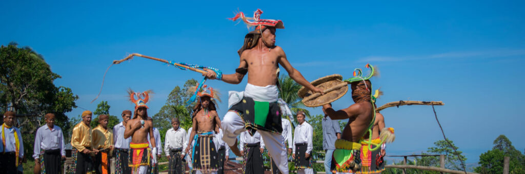 Las festividades locales también reflejan esa conexión cíclica con la naturaleza y la gratitud por la vida. En la cultura manggarai (Flores occidental), por ejemplo, cada cinco años celebran el Penti, una gran ceremonia de acción de gracias por la cosecha anual y de petición de bendiciones para el año siguiente. Durante el Penti en aldeas como Wae Rebo, todas las familias se reúnen, se sacrifican búfalos y gallinas como ofrenda, y se realizan danzas tradicionales como el Caci, una suerte de combate ritual con látigos y escudos acompañado de música de gongs.
